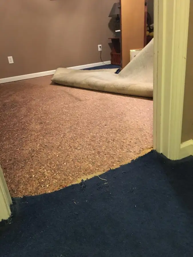 Carpet pad removal revealing water damage during Drying & Dehumidification in Salamanca